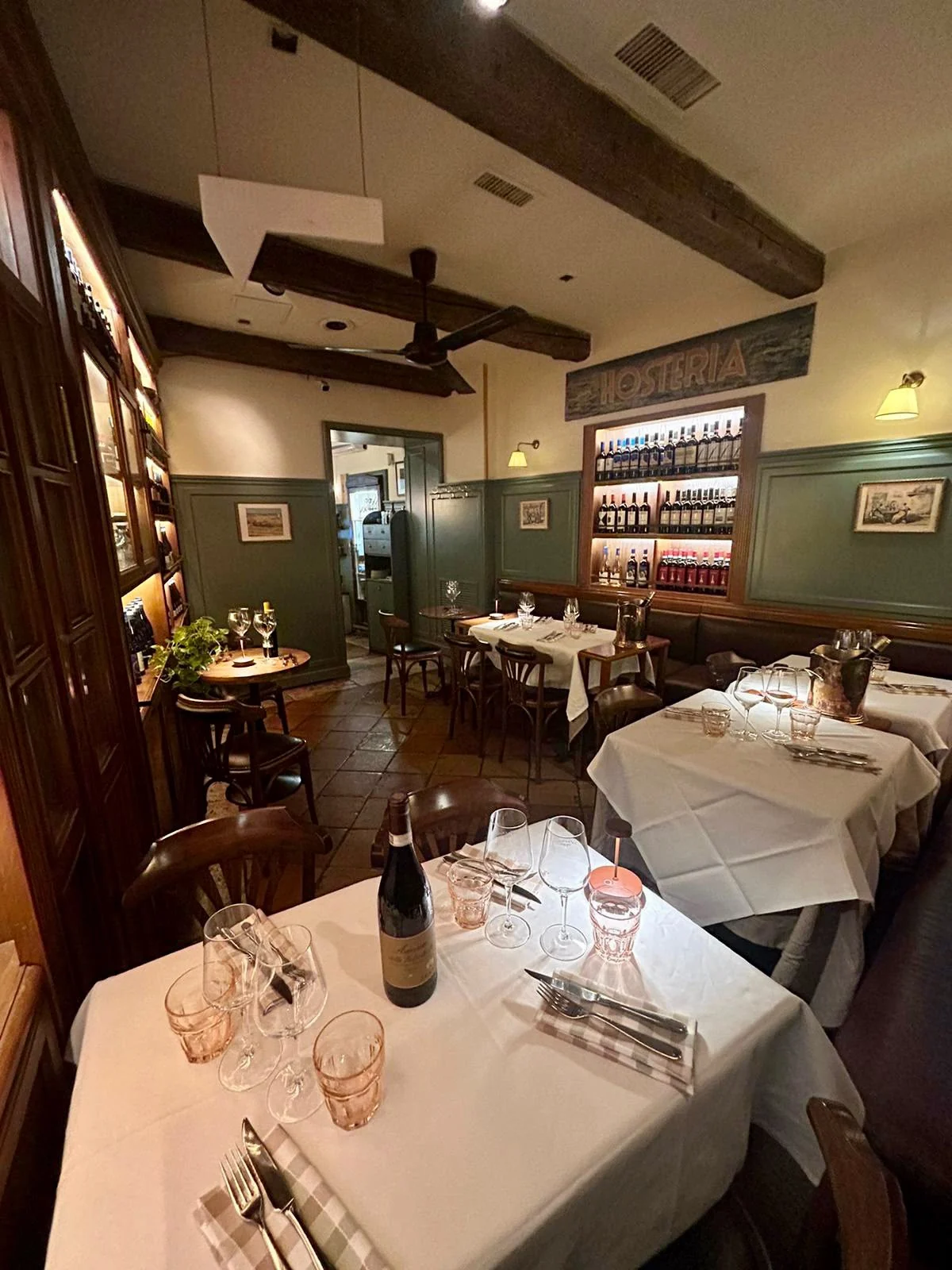Tavoli apparecchiati e cantina nella sala di Vinando